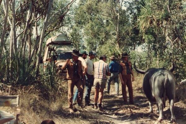 On the set of Crocodile Dundee at Fogg Dam, near Darwin, before Kel injected Charlie the Buffalo with a muscle relaxant (L-R) Paul Hogan, Kel Small, Henry Rainger, Les Jackson, a crew member,Hogan’s stand-in, and Charlie the Buffalo.