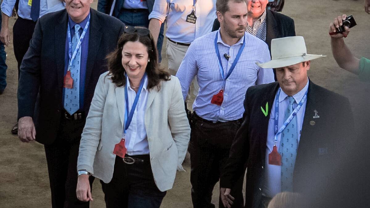 Premier Annastacia Palaszczuk smiles as she walks past chanting graziers and farmers, while she is escorted by Beef chairman Blair Angus, who wore a green ribbon in support of the rally. Photo - Kelly Butterworth.  