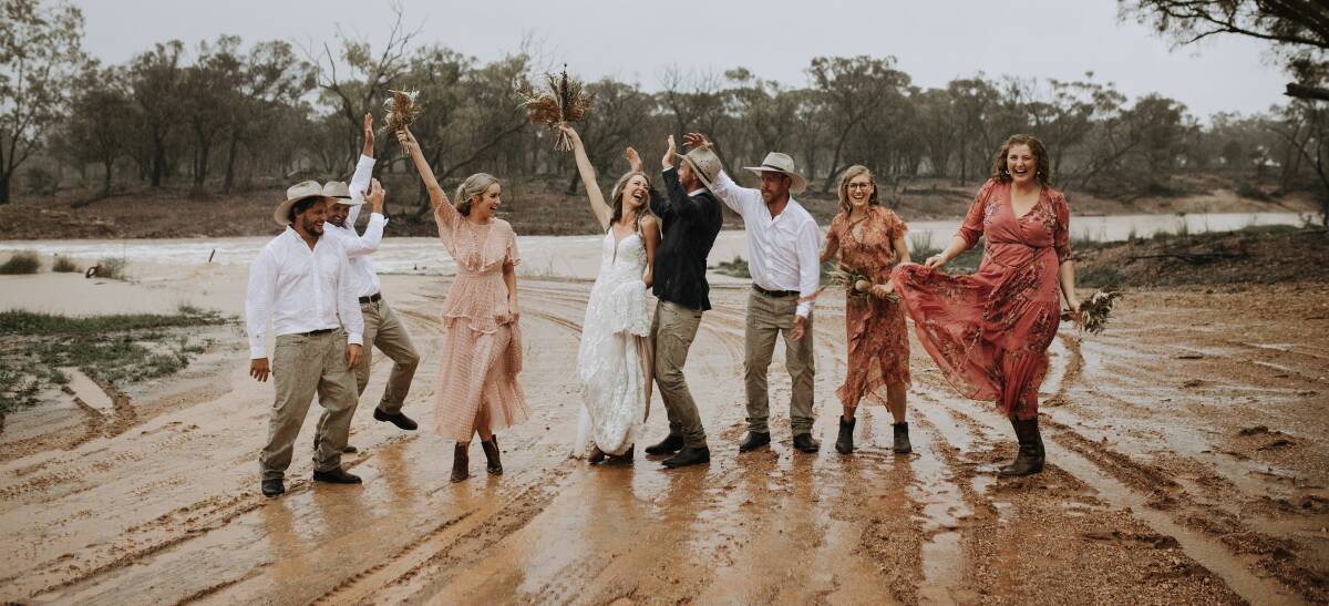 Jill and Dan Keynes celebrate the arrival of the big wet at Avon Downs on their wedding day. Photo - Jessica Turich Photorgraphy.