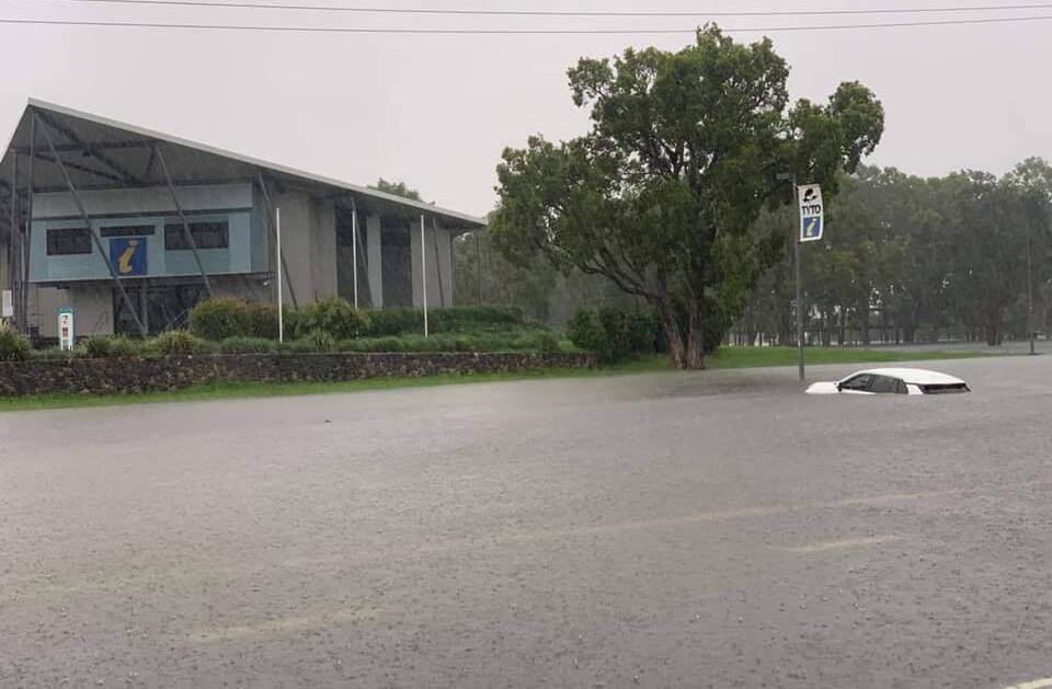 A car is washed off Townville Road opposite Tyto Wetlands in Ingham this morning. Photo: Caleb Rutherford