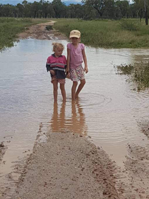 Miranda, 2 and Sierra, 5 of 12 Mile Station 180km north-west of Charters Towers enjoy playing in floodwater for the first time in their lives.