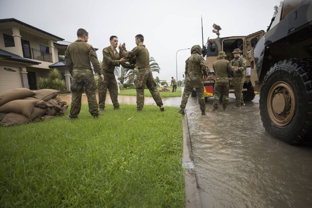 Members from the 1st Battalion, The Royal Australian Regiment supply sandbags to assist Townsville residents.