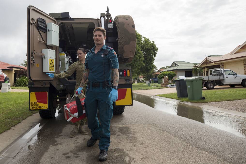 Michael Fisher from Queensland Ambulance Service and Corporal Sarah-Jane Seaton from the 1st Close Health Battalion conduct welfare patrols through flood affected Townsville.