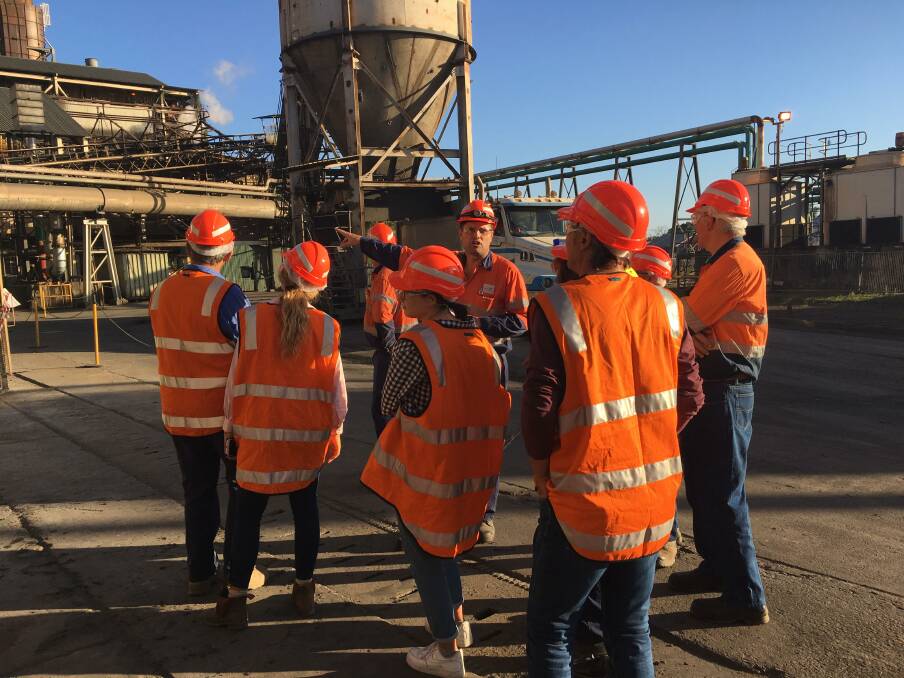 Proserpine Mill production superintendent Damien Kelly (back) shows growers a mill mud being loaded. Mill mud is returned to farms to be used as a soil ameliorant and nutrient source for sugarcane.