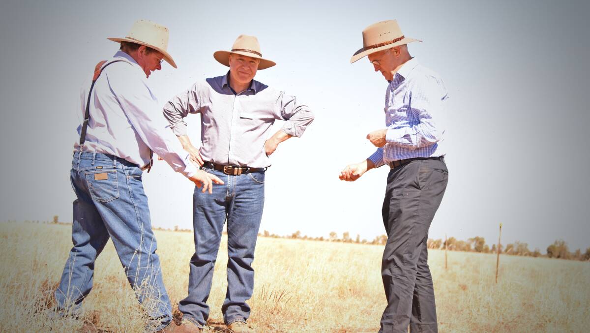Boulia mayor Rick Britton and scientist David Phelps tell the prime minister about mitchell grass on Goodwood Station. Picture: Lydia Lynch